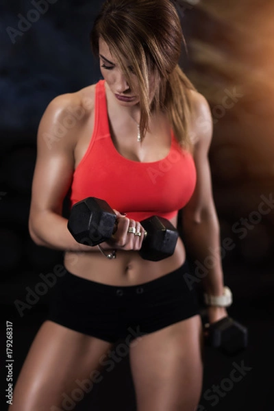 Obraz Dziewczyna ćwicząca biceps na siłowni