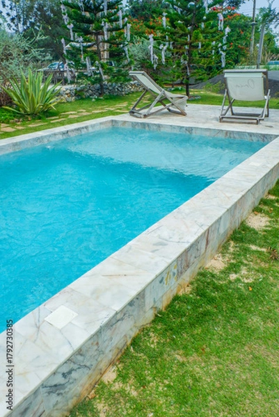 Obraz Empty swimming pool with sunbed and white umbrella in resort hotel for vacation leisure and white sand,resort neary sea and beach in summer.