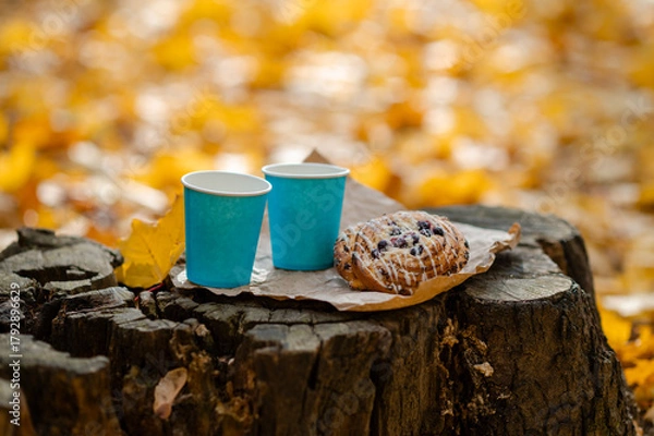 Obraz Autumn picnic concept - cups and pastries on old tree stump among colorful leaves