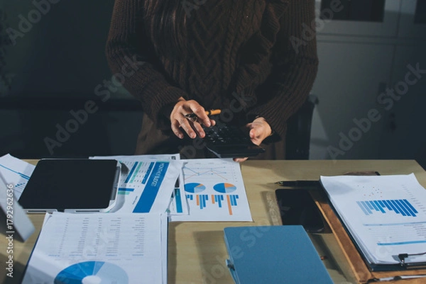 Fototapeta Close-up of businessman's hands making notes, mobiles, chart, desk, office