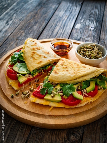 Obraz Healthy breakfast - italian piada wraps with scrambled eggs, tomatoes, avocado, coriander and bean sprouts