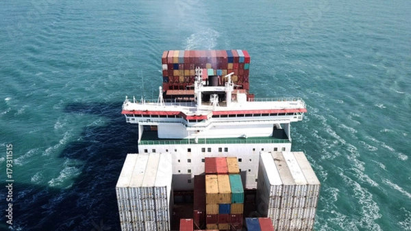 Obraz Huge large mega ULCV container ship sails on open water fully loaded with containers and cargo - aerial view