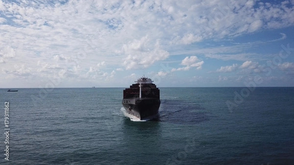 Obraz Huge large mega ULCV container ship sails on open water fully loaded with containers and cargo - aerial view