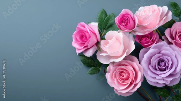 Fototapeta A beautiful floral arrangement featu light pink, hot pink, and lavender roses with green leaves is displayed on a soft blue background providing copy space.