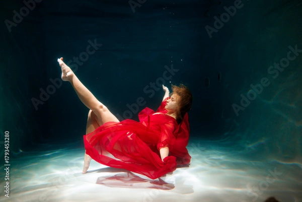 Obraz Lady in red beneath water, Redclad woman strikes pose underwater