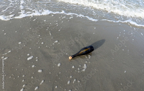Fototapeta bottle found on the beach sealed with a cork containing a secret message or a treasure map