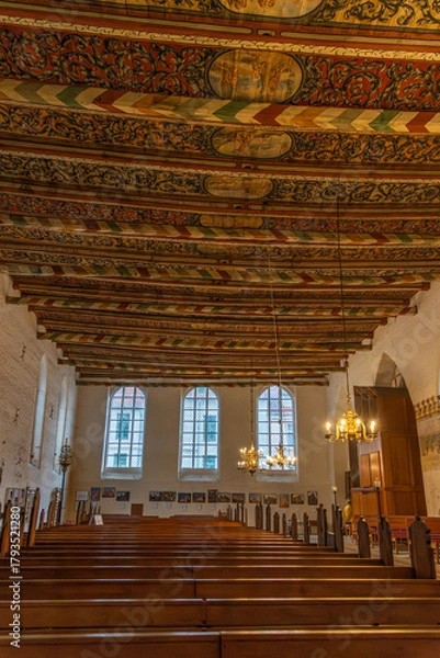 Fototapeta Nave of the historic Church of the Holy Spirit, featuring a uniquely and artistically painted wooden ceiling, with a view forward of bright windows and the organ.