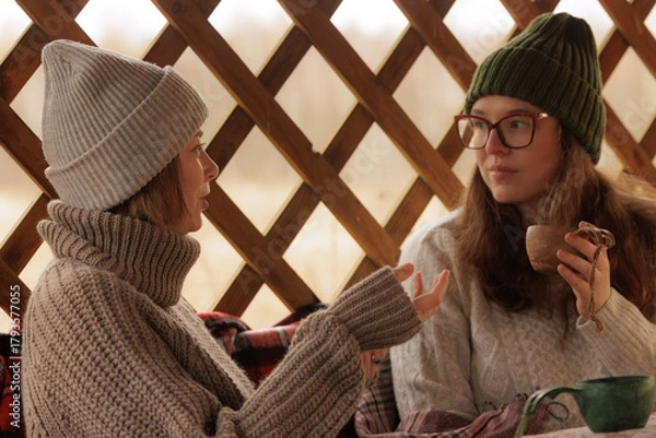 Obraz Warm conversations in a cozy cabin during a chilly winter evening