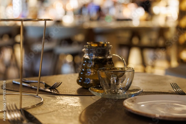 Fototapeta Elegant evening tea setup in a cozy restaurant with warm ambient lighting