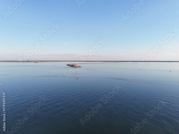 Fototapeta Aerial View Of Long Monitor Merrimac Memorial Bridge Tunnel crossing tranquil blue water of Hampton Roads Channel with a distant harbor and open sky