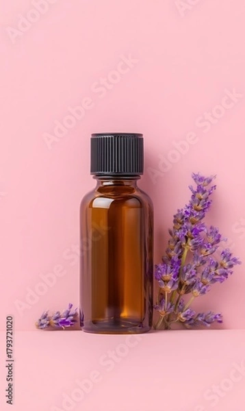 Fototapeta Amber Bottle of Essential Oil Rests With Sprigs of Lavender Against a Soft Pink Background on a Peaceful Afternoon