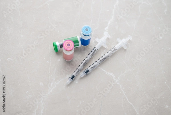 Obraz Single Use Syringes Next to Small HRT or Peptide Vials