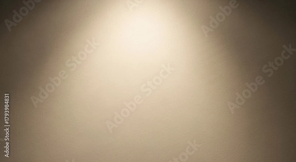 Obraz Soft spotlight illuminating a textured wall with a warm, gentle glow and subtle gradient