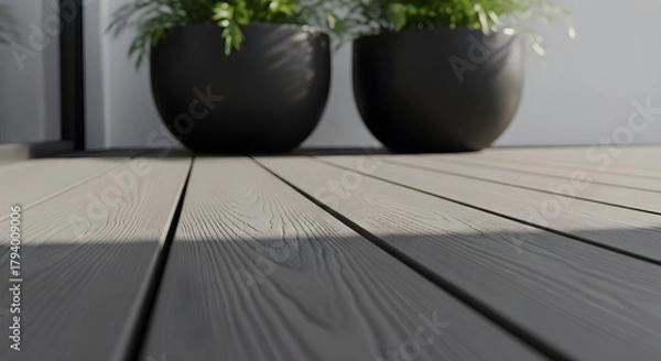 Fototapeta Close up of a modern composite deck with two dark planters holding lush green plants in soft natural light