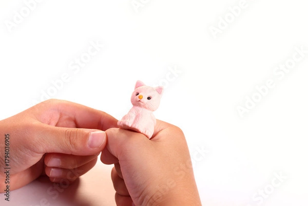 Obraz 猫の玩具を持つ幼児の手