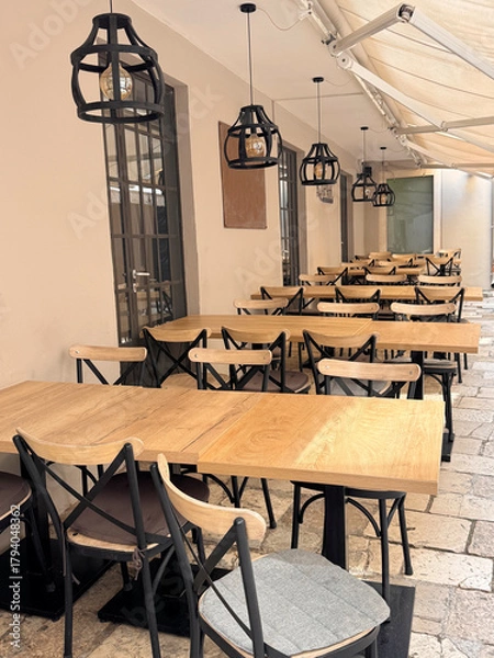 Obraz outdoor seating at a restaurant with table and chairs in a narrow street in Croatia