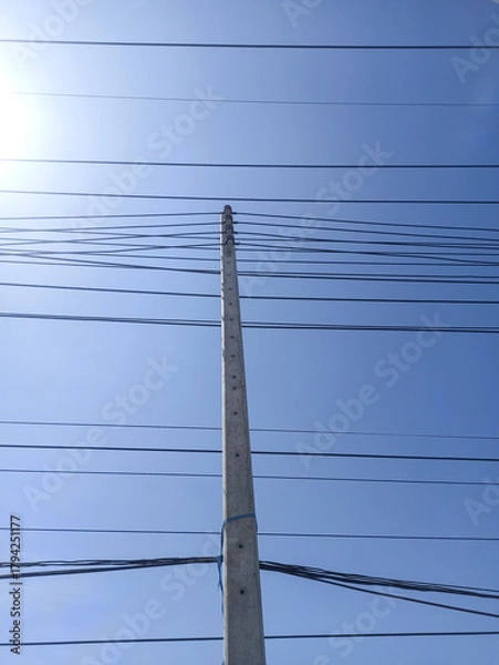 Fototapeta electricity post with blue sky and sun, power lines and wires