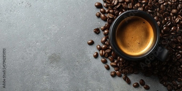 Obraz The coffee cup surrounded by roasted beans on textured gray background