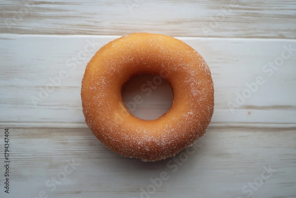Fototapeta Top View of Sugared Cruller Donut Ring on Light Wooden Surface