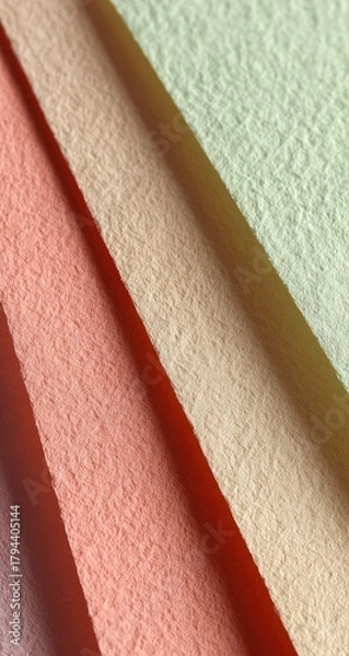 Fototapeta Close-up of four pastel-colored textured fabric swatches, diagonally arranged, showcasing subtle color variations and a slightly rough surface