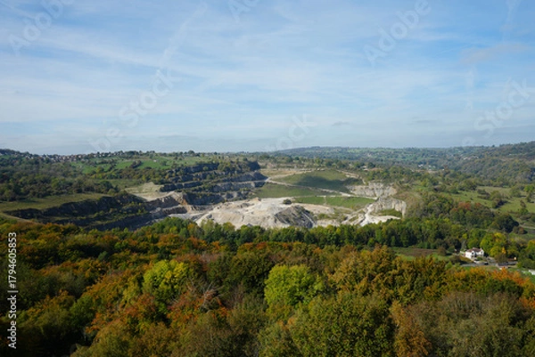 Obraz Panoramic View Of Black Rocks Quarry And The Vibrant Autumn Landscape With Hills And Distant Village Near Cromford, Derbyshire, Under A Blue Sky.