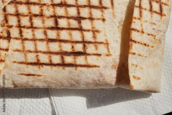 Fototapeta A French Tacos, a popular European fast food, filled with chicken and cheese