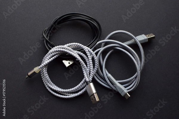 Obraz Multiple USB peripheral cables (Universal Serial Bus). USB data and power cables on a dark background. USB cable, charger. Close-up.