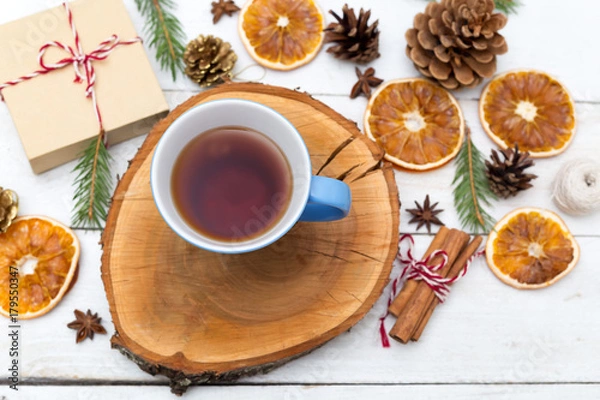 Obraz A cup of tea stands on a wooden tray, and around the Christmas decorations. Flat lay