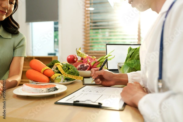 Fototapeta Dietician, male nutrition specialist consulting woman, developing healthy diet, dietary program. Dietary consultant asking, giving male patient advice, help, nutritional information, new meal plan