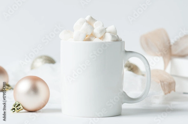 Fototapeta mug of hot chocolate with marshmallows surounded by Christmas decorations