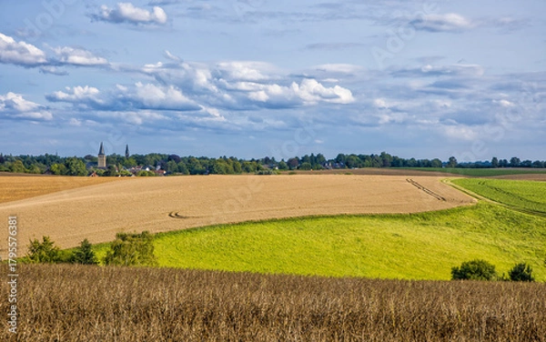Fototapeta the two churches called Wiesnasen of Ratingen Homberg at summer sun with wheat field and lush green meadow at blue cloudy sky