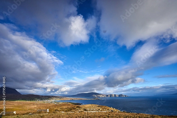 Fototapeta View over the ocean in cloudy blue sky weather with Achill island, Keel vilage and beach