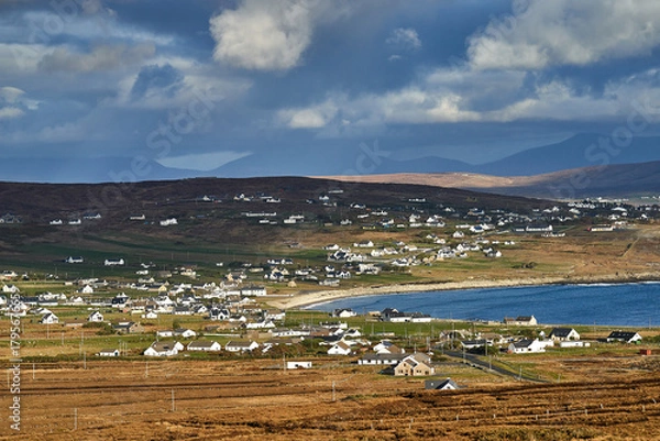 Fototapeta View over the ocean in cloudy blue sky weather with Achill island, Keel vilage and beach