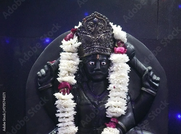 Fototapeta Shani Dev Stone Idol with Blue Decorative Lights