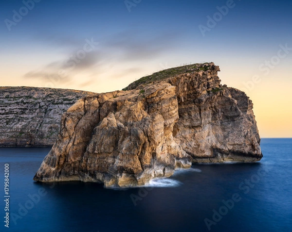 Fototapeta Breathtaking sunset view of Gozo's Fungus Rock surrounded by calm waters