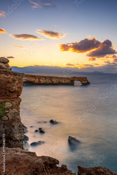 Obraz Sunset over rocky coast in Crete with tranquil sea and distant mountains