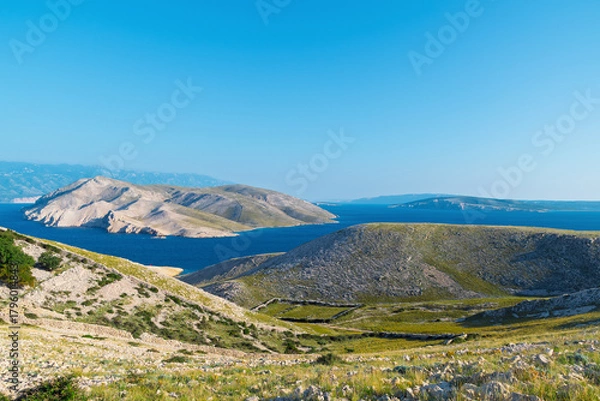 Fototapeta Serene landscape of krk island with clear blue sky and rolling hill. View of Prvic island, Croatia