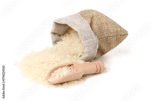 Fototapeta Rice is poured from a jute sack and scooped up with a wooden spoon. isolated on white background.