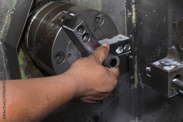 Fototapeta man load workpiece into lathe machine