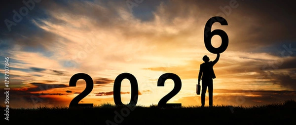 Fototapeta Silhouette of an enterprising businessman standing at dawn already active and motivated, greeting card for the new year 2026.