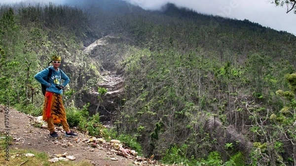 Fototapeta The guy stands against the background of a tropical forest. Adventures in Southeast Asia