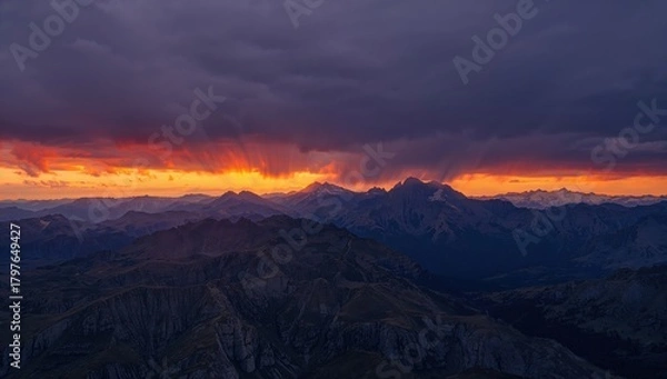 Fototapeta Aerial perspective of rugged mountains under a tempestuous sunset sky, erosion risk