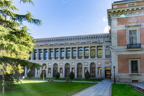 Obraz El Prado Museum on a sunny spring morning, showcasing elegant neoclassical architecture, grand statues, and lush green trees framing its bright, inviting façade with added charm