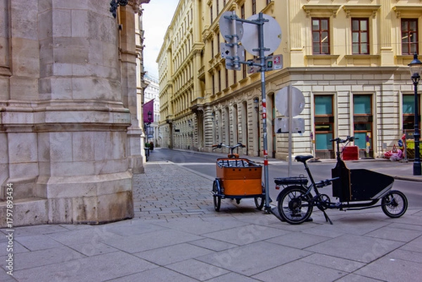 Fototapeta quiet, narrow street in Vienna, lined with historic yellow buildings, showing two cargo bikes