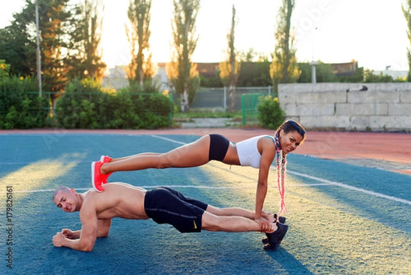Fototapeta A guy and a girl at the stadium are engaged in sports, lifestyle