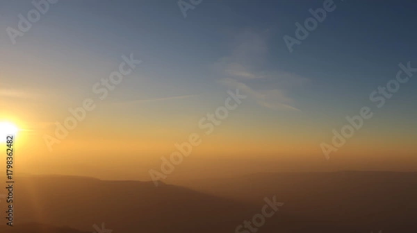 Fototapeta Sunrise over the horizon, radiating warmth and light