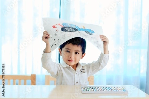 Fototapeta Cute boy learning to draw and color