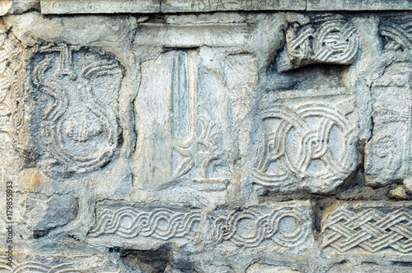 Fototapeta Часть стены древнего храма в Анакопии с сохранившимися древними орнаментами и символикой.