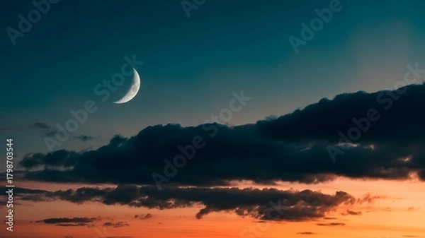 Obraz Crescent moon glowing in a dramatic twilight sky with dark clouds and vibrant orange and blue hues