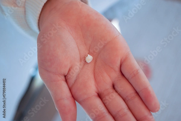 Obraz 歯が抜けた！初めての乳歯を見せる女の子のクローズアップ